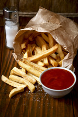 French fries with ketchup on wooden table