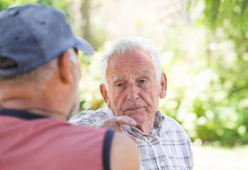 Two senior men talking in park