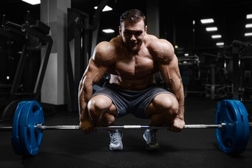 Naklejka na ściany i meble Brutal strong bodybuilder athletic men pumping up muscles with dumbbells.