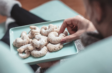 Junge Frau isst Vanillekipferl 