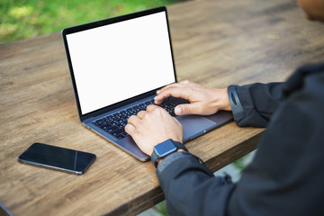 Male person sitting front open laptop computer with blank empty screen for your information or content,modern businessman work in internet via notebook, student at coffee shop learning