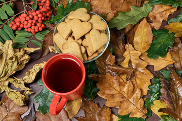 Autumn still life. Heart cookie. Rowan branch. Black tea