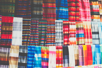 Selection of colorfu clothes on a traditional Moroccan market (souk) in Marrakech, Morocco
