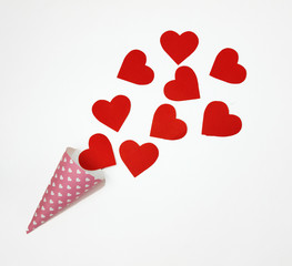 Red heart is poured from a pink horn on a white background.