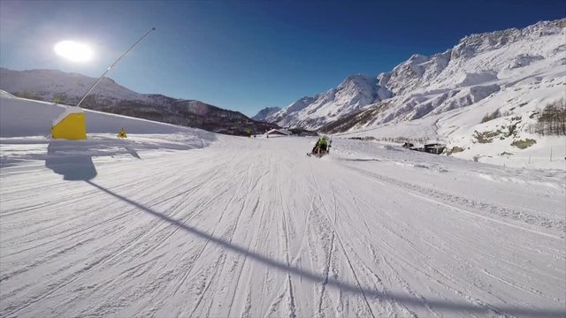 skiing on a trail while passing a snowmobile. first person pov
