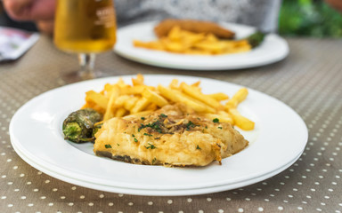 Fish with french fries on a plate, Siurana, Catalunya, Spain. Close-up.