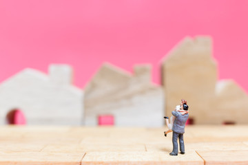 Miniature people : Couple with house on pink background , Valentine's day concept