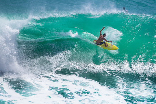 Surfer riding big green wave at Padang Padang beach, Bali, Indonesia