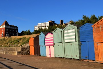Fototapeta na wymiar A Row of British Beach Huts under a clear Blue Sky