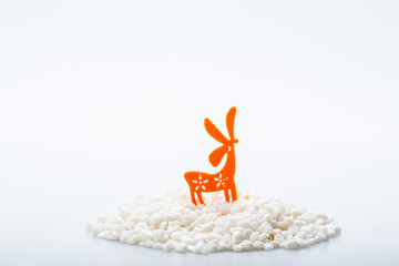 Colorful animal on top of pebbles icon isolated on white background. Concept of cuteness and element of surprise . Isolated on white background. Slightly de-focused and close-up shot. Copy space.