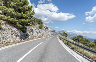 Fototapeta premium Asphalt road to the sea. Asphalt highway in a sunny day.