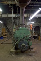 Old Boiler room in dirty old basement of warehouse building with rust and trash
