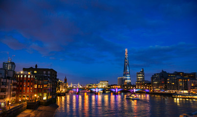 London cityscape with Southwark Bridge and Shard skyscraper at night