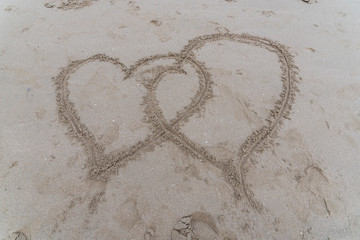 two hearts drawn on the sand