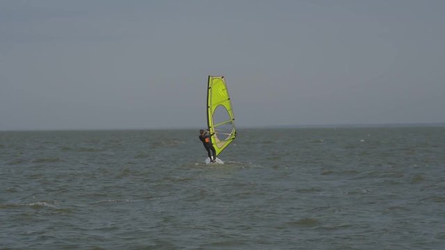 Girl on the windsurf floats away into the distance