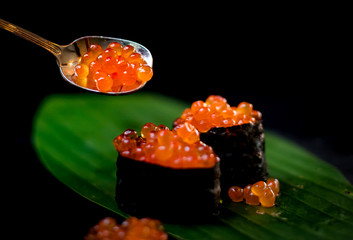Making fish egg on seaweed sushi & back background