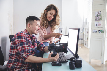 young photographer checking the photo result in computer with hi