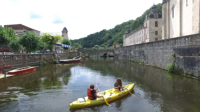 Two women canoeing down the river in Brantome france, enoying the view