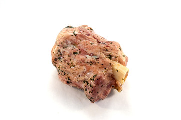 Pork ham with its bone and green parsley on a white background