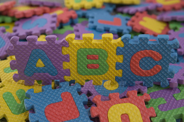 the alphabet children's puzzles. abc against the background of scattered colored pieces of the puzzle