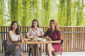 group of three best friend having their lunch together at a cafe