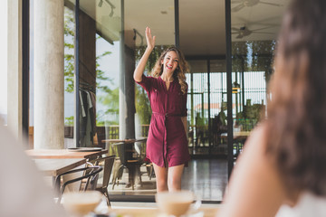 beautiful woman waving her hands to her friends