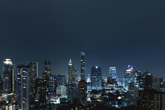 Fototapeta City scape over night sky. Groups of tall commercial building on night sky in background.