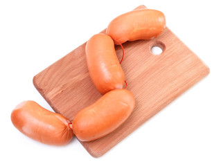Meat sausages on wooden plate isolated on white background