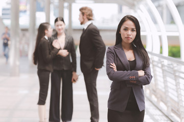 Confident looking mixed race business woman posing arm cross.