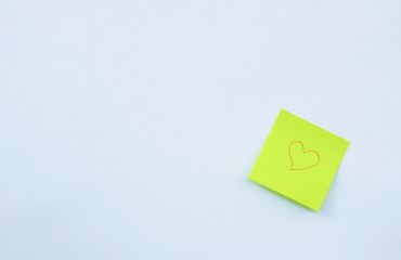 yellow paper note drawing red heart shape stick on white background