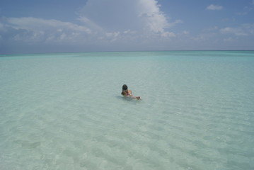 Girl swimming in a amazing beach of Maldives islands