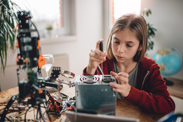 Fototapeta na wymiar Girl modifying power supply and learning robotics