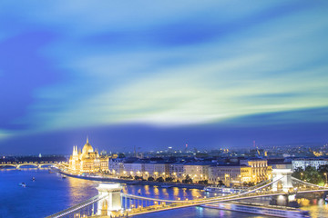 Fototapeta na wymiar Beautiful view of the Hungarian Parliament and the Szechenyi chain bridge across the Danube in the panorama of Budapest at night, Hungary