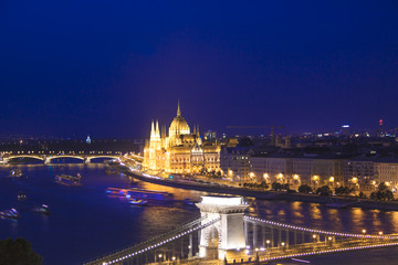Beautiful view of the Hungarian Parliament and the Szechenyi chain bridge across the Danube in the panorama of Budapest at night, Hungary
