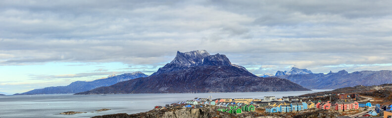 Panorama of сolorful Inuit houses on a coastline in a suburb of Nuuk with Sermitsiaq mountain and fjord in the background, Greenland © vadim.nefedov