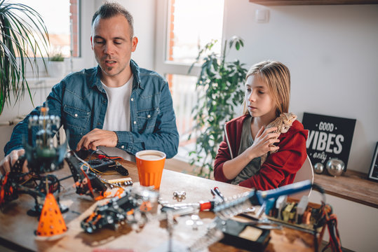 Father and daughter building robot