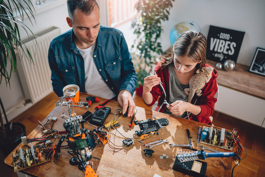 Father and daughter building robot