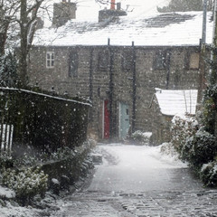 the village of heptonstall in snowfall showing ancient houses and small lane