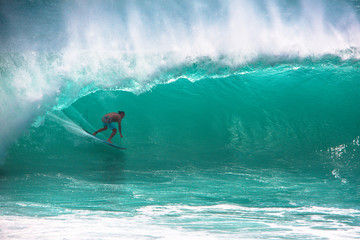 Surfer riding big wave at Padang Padang beach, Bali, Indonesia