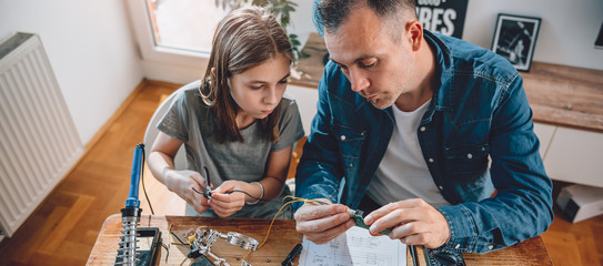 Father and daughter building robot