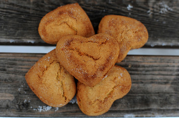 Homemade cookies with sugar and cinnamon in the form of hearts on a wooden background
