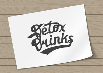 Badge Detox Drinks with Hand Drawn Lettering on A4 Sheet Paper on Wooden Background. Green Emblem Vector Illustration.
