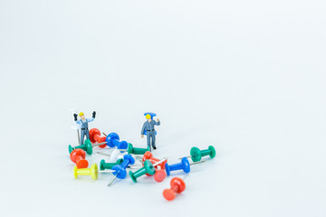 Obraz premium Selective focus of Miniature Worker People, Working with push pin , on white background