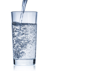 Flowing pure water into tumbler on white background