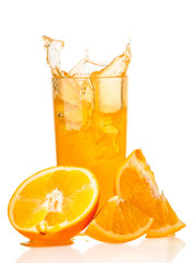 Orange juice splash in glass and slices of orange on white background