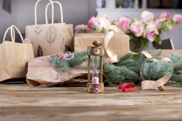 Naklejka na ściany i meble hourglass on a wooden background and gifts and roses