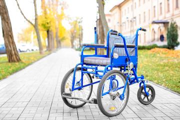 Fototapeta premium Blue wheelchair outdoors on sunny day