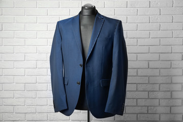 Semi-ready suit on mannequin against brick wall background