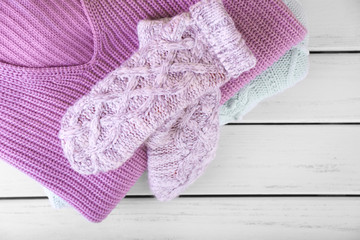 Warm knitted clothes on table. Seasonal female wardrobe