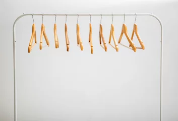 Fotobehang Wardrobe stand with hangers on light background © Africa Studio